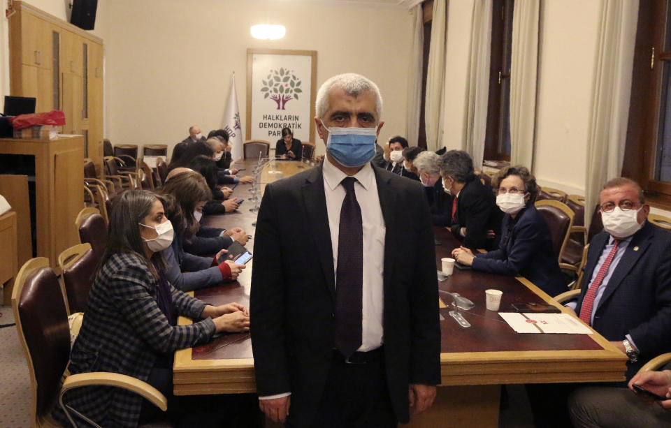 Omer Faruk Gergerlioglu, a human rights advocate and lawmaker from the People's Democratic Party, or HDP, stands in front with his colleagues sitting in support after the parliament stripped his parliamentary seat, in Ankara, Turkey, Wednesday, March 17, 2021. Turkey has stripped a pro-Kurdish party legislator of his parliamentary seat following his conviction over a 2016 social media post and took steps toward disbanding his party. Omer Faruk Gergerlioglu, a human rights advocate and lawmaker from the People’s Democratic Party, was convicted over a social media post which the courts deemed to be terrorist propaganda. (AP Photo)