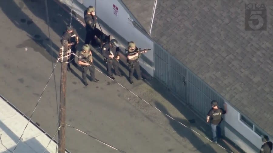 Police officers and SWAT Team members surround a housing complex after a 13-year-old boy was shot to death in Anaheim on April 17, 2024. (KTLA)