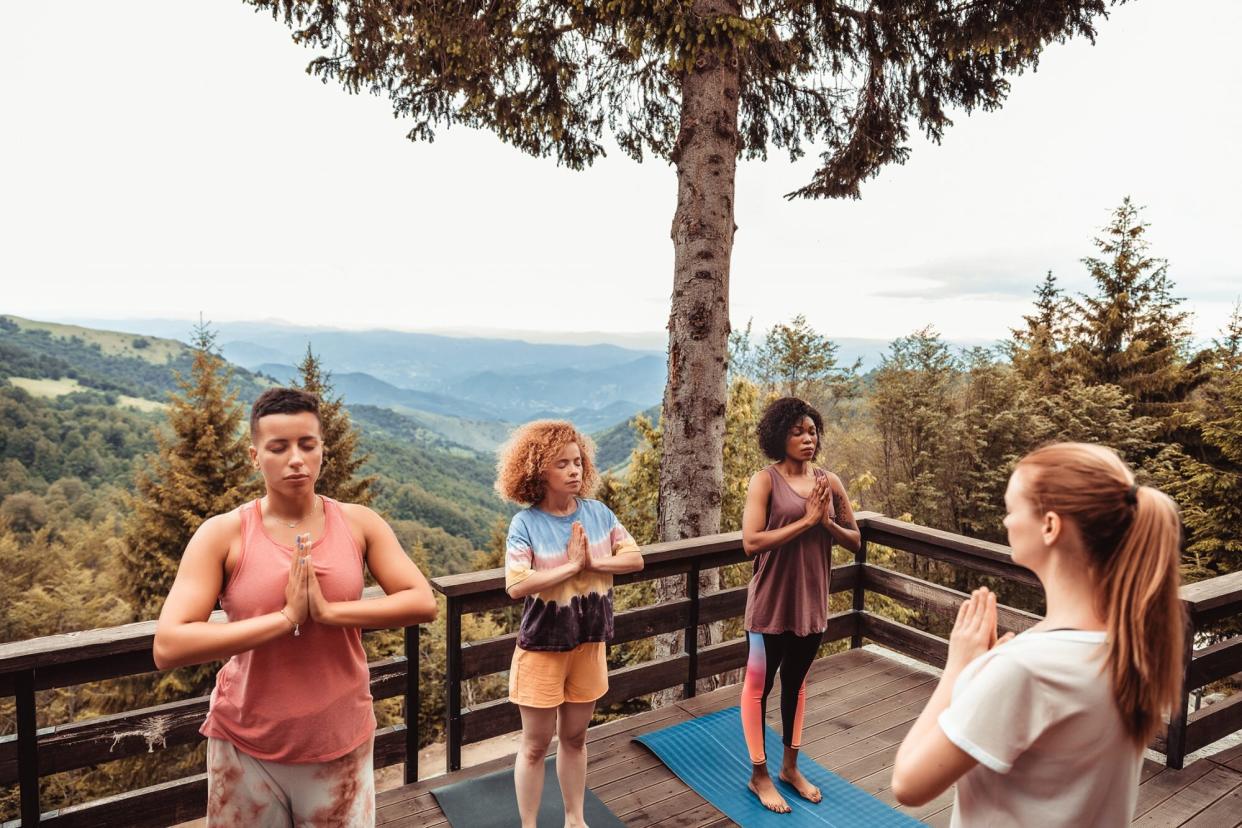 Women doing yoga on a deck in the mountains