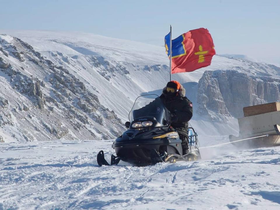 RCMP officer Cpl. Tom Cooke of Pelly Bay, Nunavut, rides his snowmobile up a hill on March 29, 2007, on his way to Alexandra Fjord. (Dianne Whelan/Canadian Press - image credit)