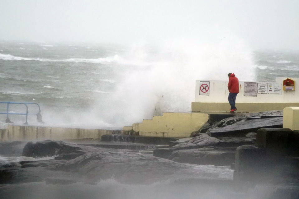 A person looks at high waves in Salthill, Galway, Ireland, Sunday, Jan. 21, 2024, during Storm Isha. (Niall Carson/PA via AP)