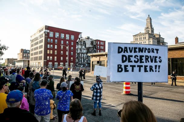 PHOTO: Davenport police officers form a line opposite protesters that are advocating for search efforts to continue near the site of an apartment building that partially collapsed in Davenport, Iowa, May 30, 2023. (Joseph Cress/USA Today Network via Reuters)