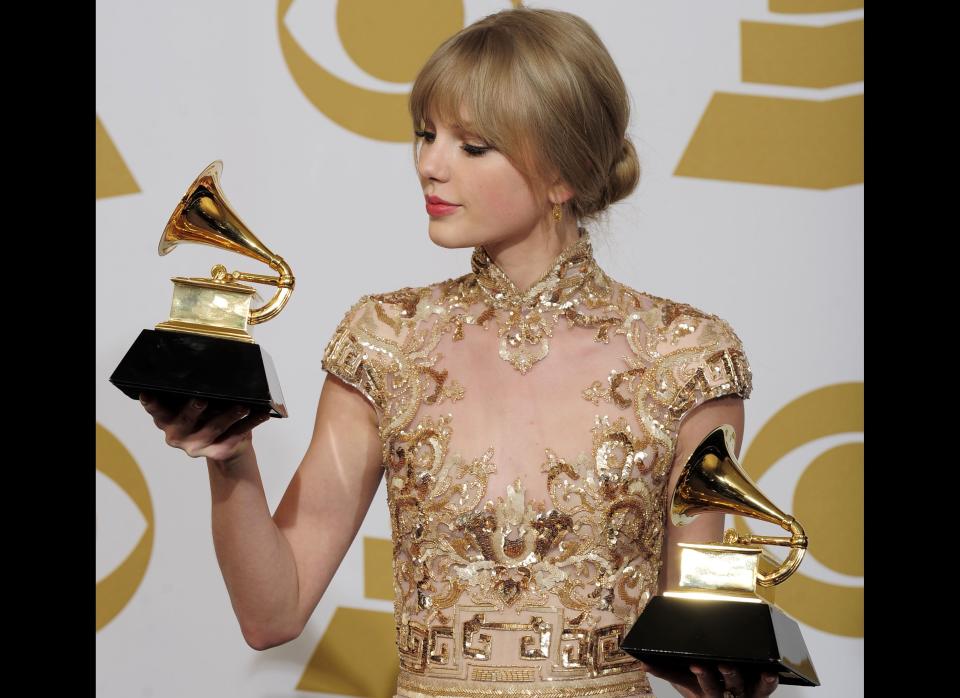 Taylor Swift poses backstage with the awards for best country song and best country solo performance for "Mean" at the 54th annual Grammy Awards on Sunday, Feb. 12, 2012 in Los Angeles. (AP Photo/Mark J. Terrill)