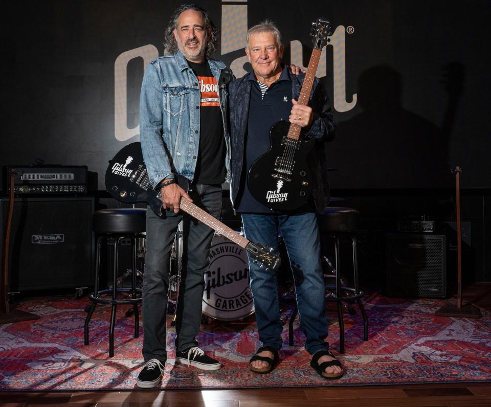 Gibson Guitars CEO  JC Curleigh and Rush guitarist Alex Lifeson pose for a portrait at the Gibson Garage Tuesday, Aug. 16, 2022, in Nashville, Tenn.  Alex Lifeson teamed with Gibson's philanthropic wing Gibson Gives to donate roughly $40,000 to Monroe Children's Hospital and Room at the Inn.