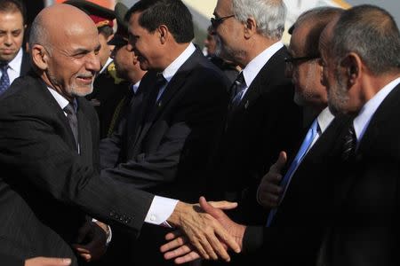 Afghan President Ashraf Ghani (L) shakes hands with Afghan officials after arriving at Chaklala Airbase in Rawalpindi near Islamabad November 14, 2014. REUTERS/Faisal Mahmood