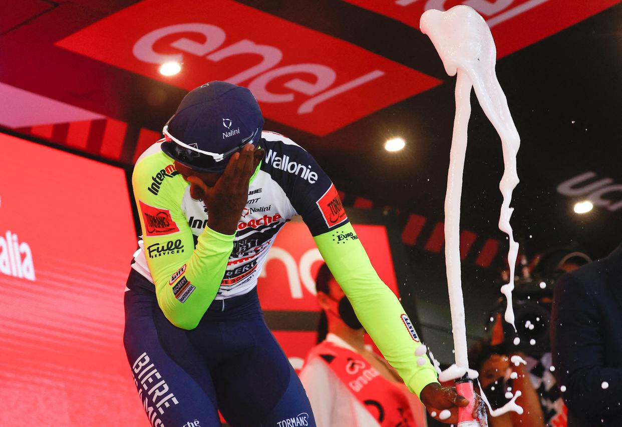 Team Wanty's Biniam Girmay Hailu reacts after popping a champagne cork as he celebrates on the podium after winning the 10th stage of the Giro d'Italia 2022 cycling race on May 17. (LUCA BETTINI/AFP via Getty Images)