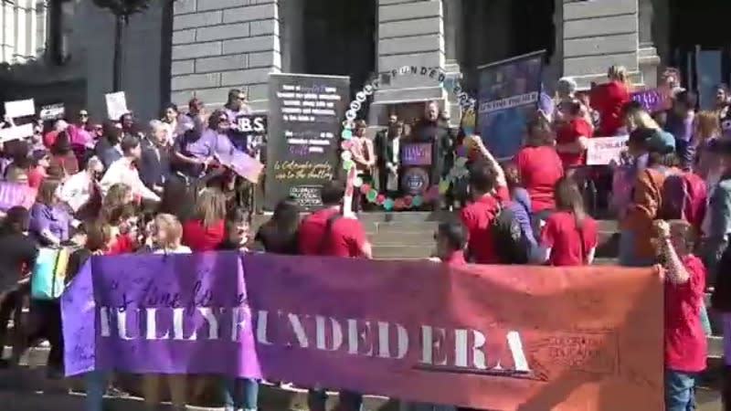 A rally at the Capitol with a banner that says "FULLY FUNDED ERA"