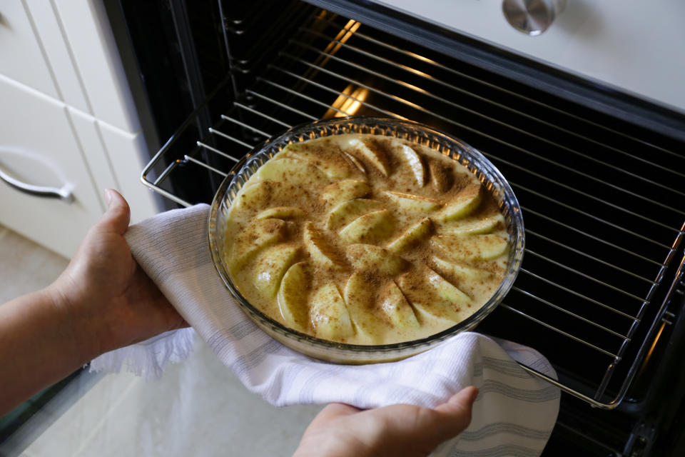 Pulling a pie out of the oven.