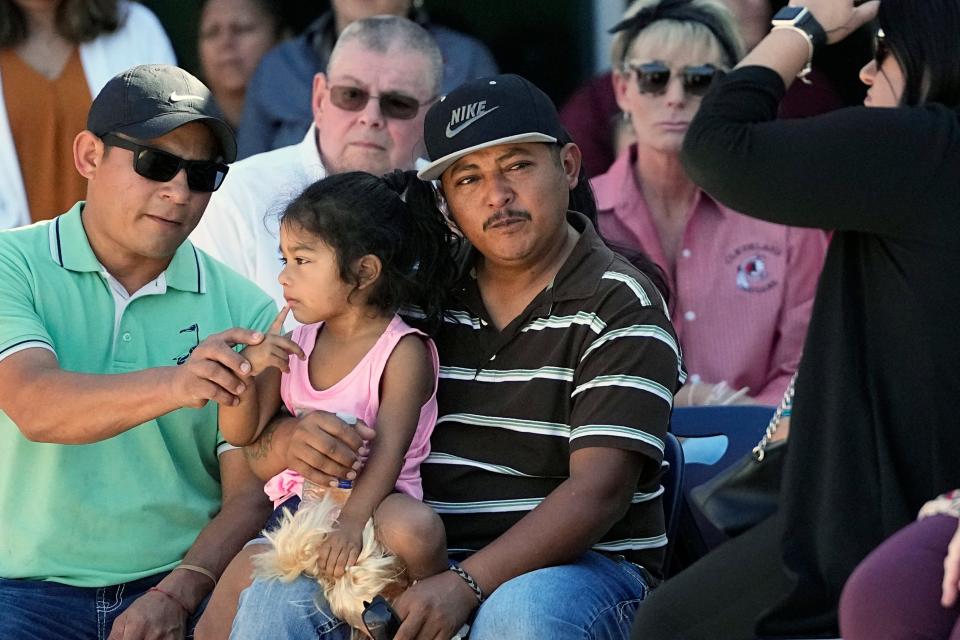 Mass shooting survivor Wilson Garcia, center, holds a young girl during a vigil for his son Daniel Enrique Laso, 9, on Sunday in Cleveland, Texas.