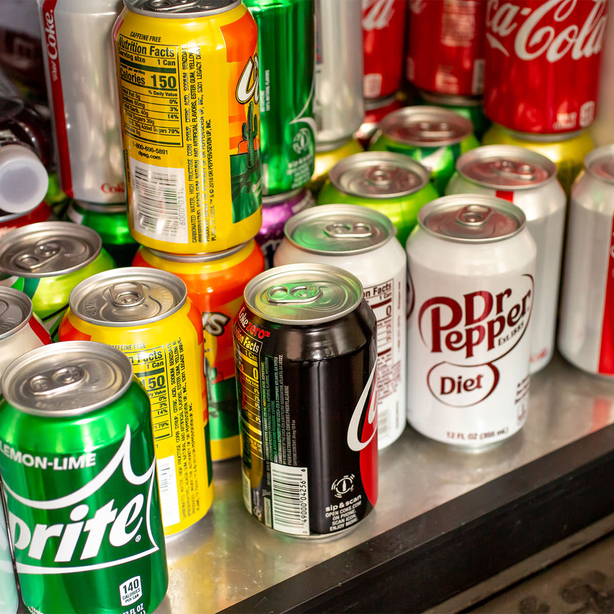 cans of sprite, diet doctor pepper, and other sodas in fridge
