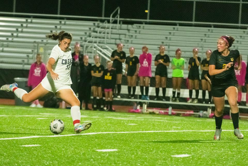 C.B. East midfielder Elliot Forney takes a shot as C.B. West player Alexis Castro moves in. [PHOTO / MARION CALLAHAN}