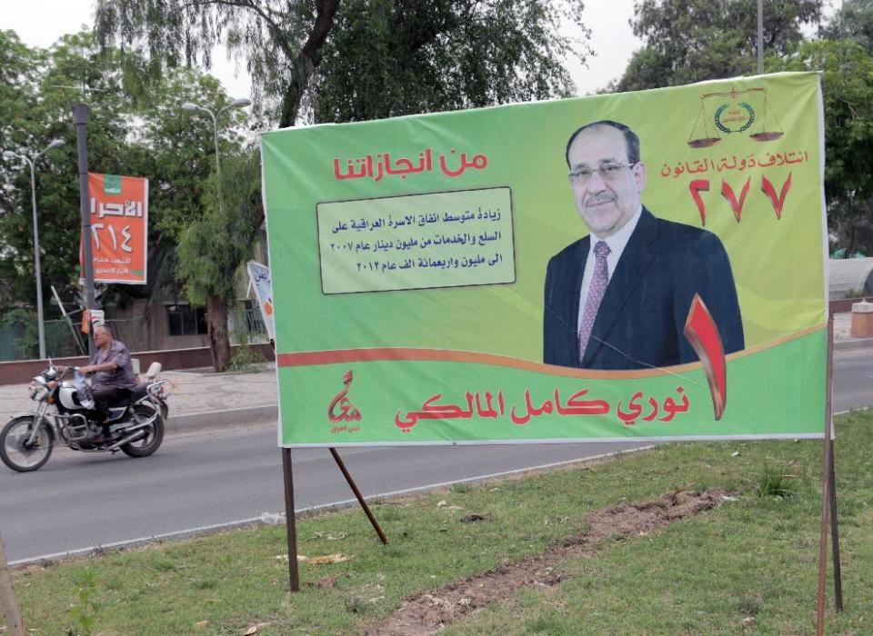 FILE - In this file photo taken on April 27, 2014 a motorcycle passes by a campaign poster of Iraqi Prime Minister Nouri al-Maliki at Abu Nawas Street in Baghdad, Iraq. If Iraqi Prime Minister Nouri al-Maliki wins a third four-year term in parliamentary elections Wednesday, he is likely to rely on a narrow sectarian Shiite base, only fueling divisions as Iraq slides deeper into bloody Shiite-Sunni hatreds. (AP Photo/Khalid Mohammed, File)