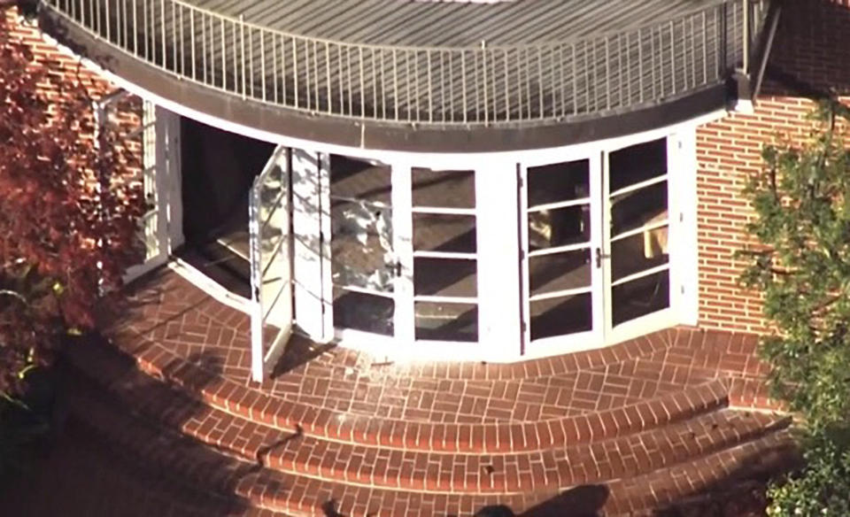 A screen grab taken from aerial video shows one of three double French doors opening onto circular back brick steps littered with broken glass.