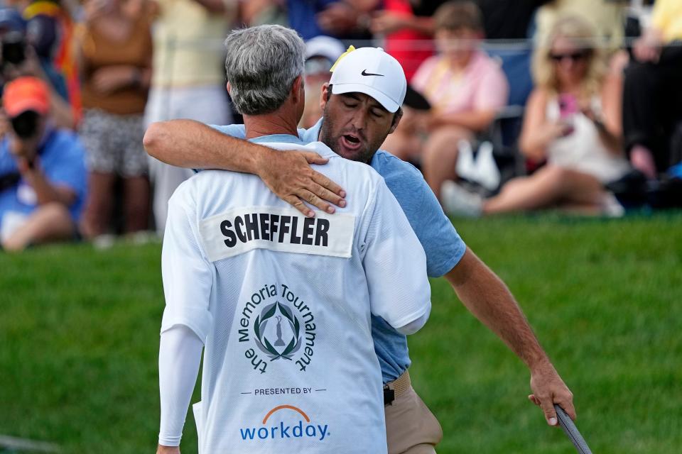 Jun 9, 2024; Dublin, Ohio, USA; Scottie Scheffler reacts with his caddie after winning the Memorial Tournament at Muirfield Village Golf Club. Mandatory Credit: Adam Cairns-USA TODAY Sports