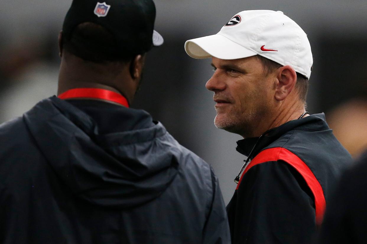 Georgia football analyst Mike Bobo speaks with an NFL scout during Georgia's Pro Day in Athens on Wednesday, March 16, 2022.