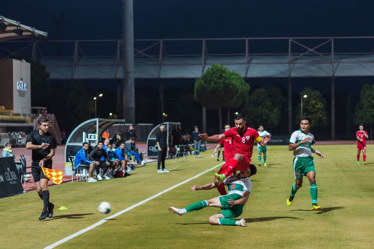 Farshad Noor (8), capitán de la selección de Afganistán, choca con un jugador indonesio durante el amistoso internacional entre los dos países en el Gloria Sports Arena en Antalya