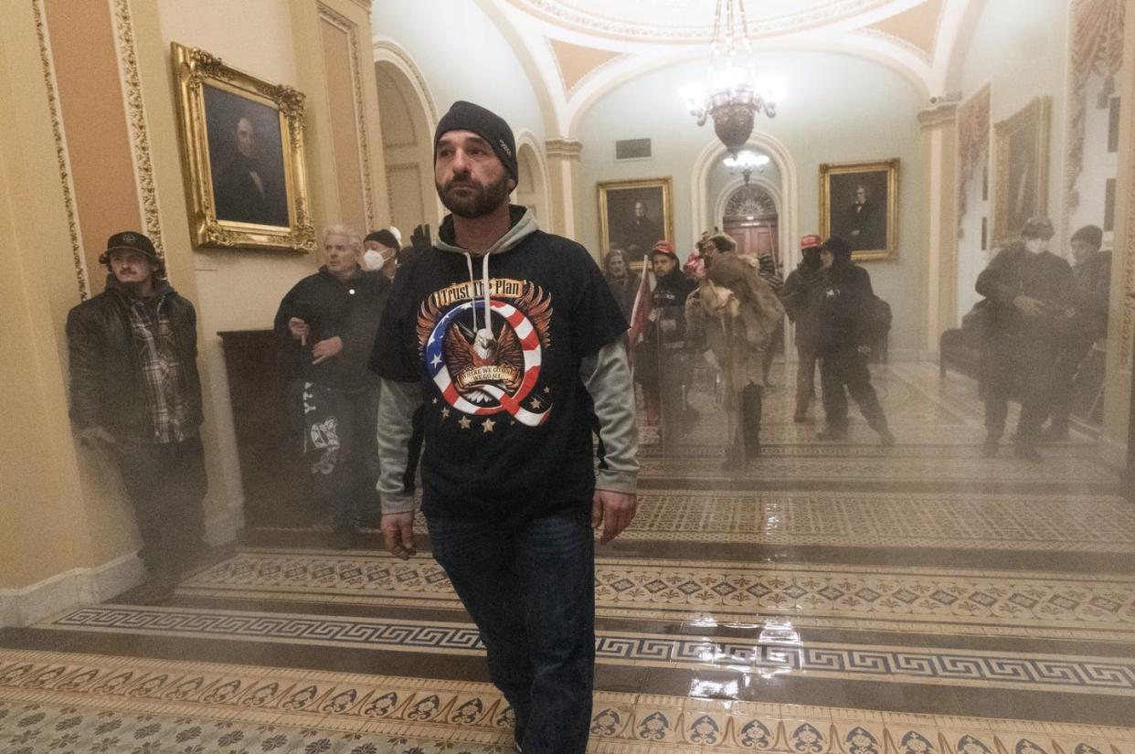 <span class="caption">A man wearing a T-shirt alluding to the QAnon misinformation campaign walks through the U.S. Capitol during the Jan. 6 incursion.</span> <span class="attribution"><a class="link " href="https://newsroom.ap.org/detail/CapitolBreachSocialMedia/7a54ed4854aa450cb08339ae2e2c1ee8/photo" rel="nofollow noopener" target="_blank" data-ylk="slk:AP Photo/Manuel Balce Ceneta;elm:context_link;itc:0;sec:content-canvas">AP Photo/Manuel Balce Ceneta</a></span>