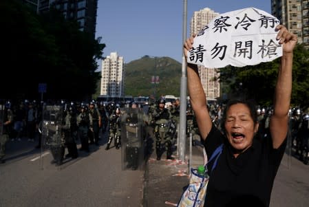 An anti-government protester holds a sign during a march in Tuen Mun, Hong Kong