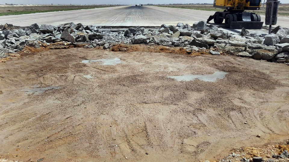 This photo released Sunday June 12, 2022 by the Syrian official news agency SANA, shows a bulldozer work at a damaged runway of the Damascus International Airport, which was hit by an Israeli airstrike on Friday, in Damascus, Syria. Syria's Transportation Ministry said the Israeli airstrike caused "significant" damage to infrastructure and rendered the main runway unserviceable until further notice. (SANA via AP)