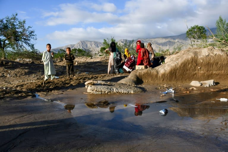 Afghans sit near damaged houses after floods in Burka district of Baghlan province (Atif ARYAN)