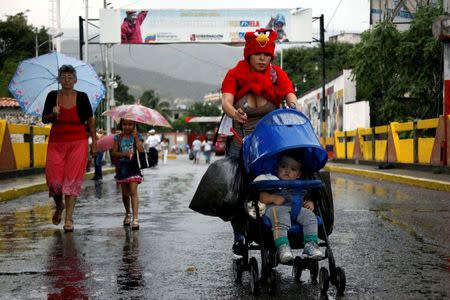 A woman push a pram with a baby and bags as she crosses the Colombian-Venezuelan border over the Simon Bolivar international bridge after shopping, in San Antonio del Tachira, Venezuela, July 16, 2016. REUTERS/Carlos Eduardo Ramirez