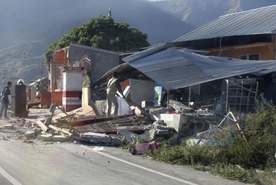 Indonesian men inspect buildings damaged by an earthquake in Sembalun, on Lombok Island, Indonesia, Monday, Aug. 6, 2018. The powerful earthquake struck the Indonesian tourist island of Lombok, killing a number of people and shaking neighboring Bali, as authorities on Monday said thousands of houses were damaged and the death toll could climb. (AP Photo/Adrial Pranandi)