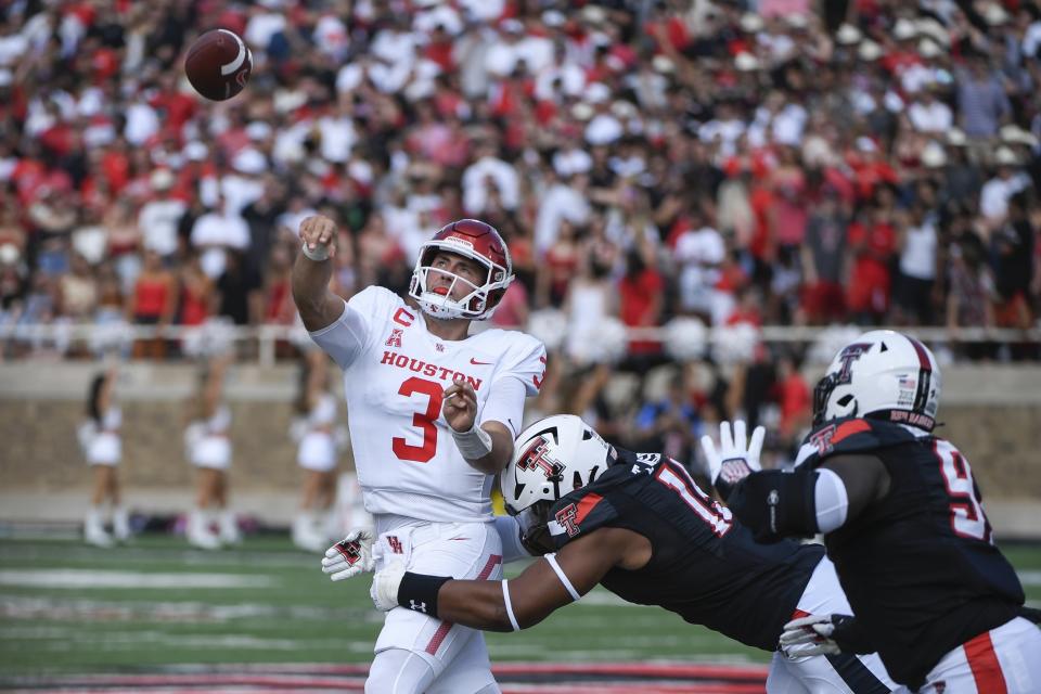 CORRECTS CITY TO IN LUBBOCK, TEXAS - Houston quarterback Clayton Tune (3) throws the ball away under pressure from Texas Tech linebacker Tyree Wilson during the first half of an NCAA college football game Saturday, Sept. 10, 2022, in Lubbock, Texas. (AP Photo/Justin Rex)
