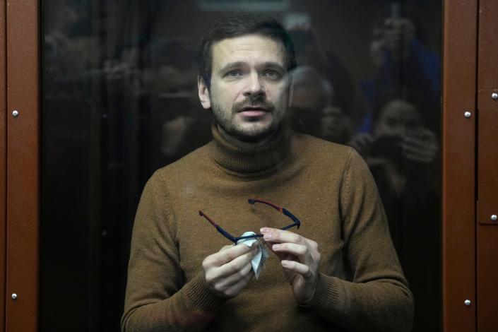 Russian opposition activist Ilya Yashin stands inside a glass cubicle in a courtroom prior to a hearing in Moscow on Dec. 5, 2022. Yashin faces trial on charges stemming from his criticism of the Kremlin's action in Ukraine.