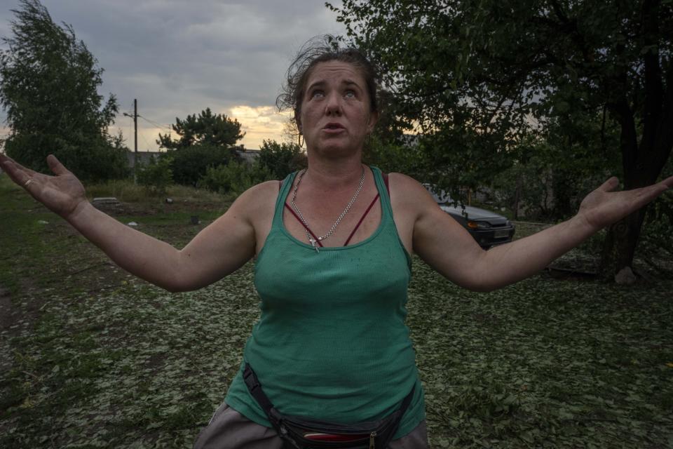 Tetiana Pashko, a 43-year-old resident, speaks in front of her damaged home, in the aftermath of a rocket attack on the outskirts of Pokrovsk, eastern Ukraine, Saturday, July 16, 2022. (AP Photo/Nariman El-Mofty)