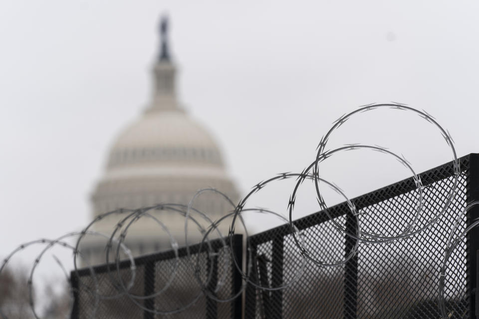 FILE - In this Feb. 18, 2021, file photo the U.S. Capitol is seen behind the razor fence around the U.S. Capitol. (AP Photo/Manuel Balce Ceneta, File)