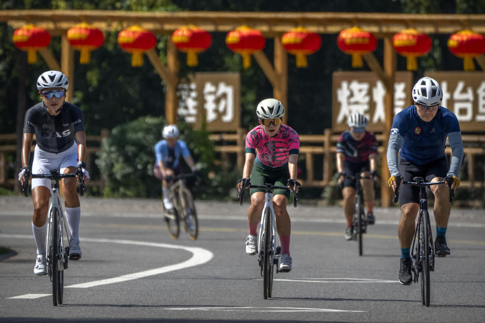 Members of the Qiyi bicycle club ride along a rural road during a group ride through the Baihe River Canyon in the northern outskirts of Beijing, Wednesday, July 13, 2022. Cycling has gained increasing popularity in China as a sport. A coronavirus outbreak that shut down indoor sports facilities in Beijing earlier this year encouraged people to try outdoor sports including cycling. (AP Photo/Mark Schiefelbein)