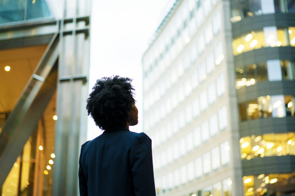 Woman looking up at office buildings