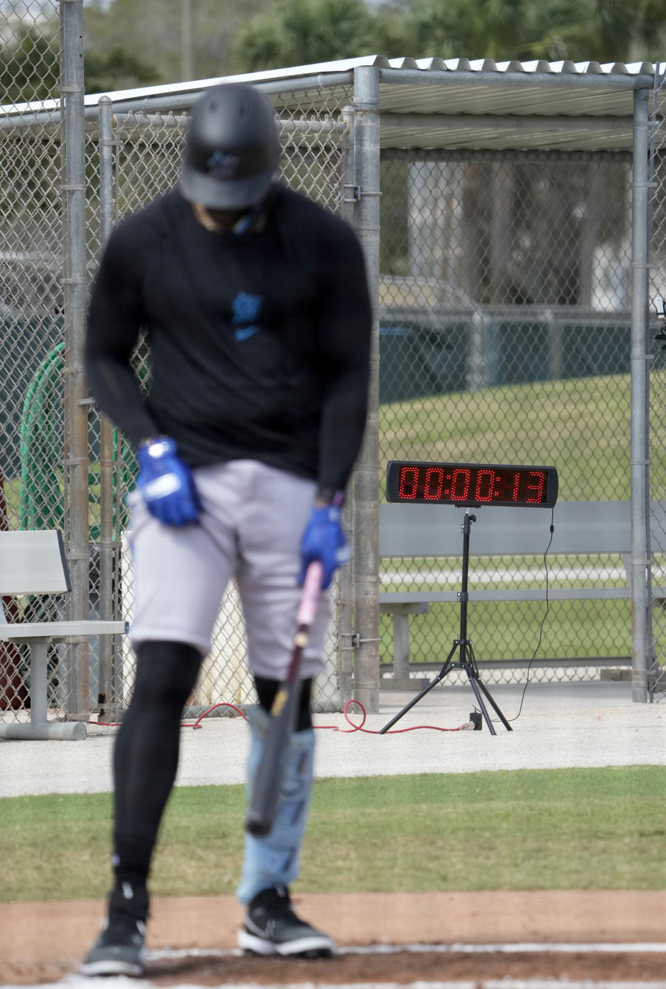 Miami Marlins' Jorge Soler steps into the batter's box as a pitch clock is seen in the background during spring training baseball practice Sunday, Feb. 19, 2023, in Jupiter, Fla. (AP Photo/Jeff Roberson)