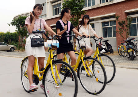 Students pose for pictures as they use OFO sharing bicycles at campus in Zhengzhou, Henan province, China, September 6, 2016. Picture taken September 6, 2016. China Daily/via REUTERS