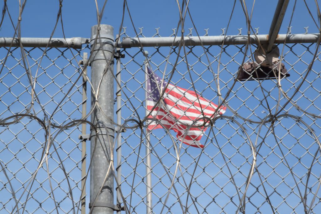 The American flag behind a chain link fence