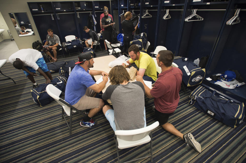 FILE - In this April 8, 2015, file photo, members of the Biloxi Shuckers minor league baseball team eat lunch before practice at the Pensacola Blue Wahoos' stadium in Pensacola, Fla. Major League Baseball is raising the minimum salary for minor league players in 2021, according to a memo sent from the commissioner’s office to all 30 teams obtained by The Associated Press. (AP Photo/Michael Spooneybarger, File)