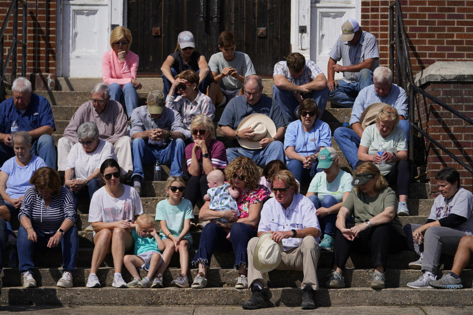 People sit and pray on the steps of the Rolling Fork United Methodist Church while worshiping, Sunday, March 26, 2023, in Rolling Fork, Miss. Emergency officials in Mississippi say several people have been killed by tornadoes that tore through the state on Friday night, destroying buildings and knocking out power as severe weather produced hail the size of golf balls moved through several southern states. (AP Photo/Julio Cortez)