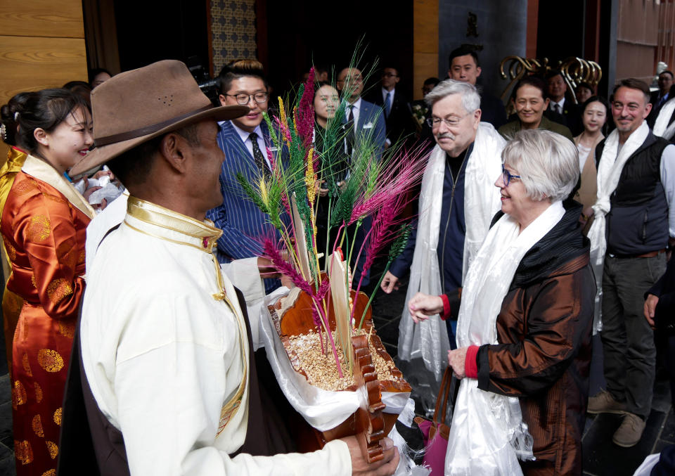 In this photo taken May 21, 2019, and released by the U.S. Embassy in Beijing, U.S. Ambassador to China Terry Branstad and his wife Christine are greeted in Lhasa in western China's Tibet Autonomous Region. The U.S. ambassador to China made a rare visit to Tibet this week to meet local officials and raise concerns about restrictions on Buddhist practices and the preservation of the Himalayan region's unique culture and language. (U.S. Mission to China via AP)