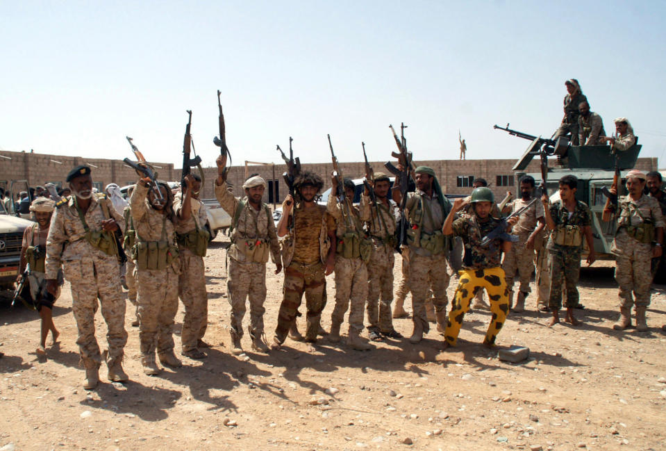 In this photo provided by Yemen's Defense Ministry, Yemen's army soldiers hold up their weapons at an area seized from al-Qaida in the southeastern province of Shabwa, Yemen, Thursday, May 8, 2014. Yemeni armed forces on Thursday swept al-Qaida fighters out of a district in the country's south, one of the main goals of the major offensive waged by the military the past two weeks, the Defense Ministry said, amid fears of retaliatory attacks which officials say prompted the closure of the U.S. Embassy in the capital as a precaution. (AP Photo/Yemen's Defense Ministry)