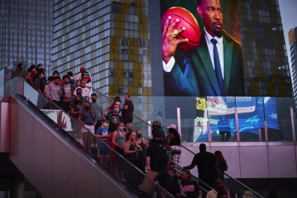 People ride an escalator along the Las Vegas Strip, Saturday, April 24, 2021, in Las Vegas. Las Vegas is bouncing back to pre-coronavirus pandemic levels, with increases in airport passengers and tourism. (AP Photo/John Locher)