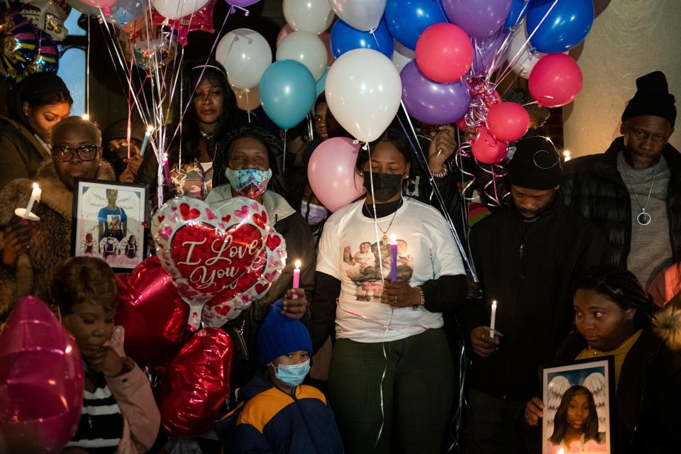 Family members gather by the Bache-Martin School for a vigil Thursday, Jan. 6, 2022 to honor the victims of a rowhouse fire in Philadelphia.