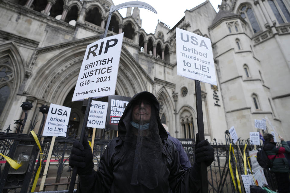 A protestor stands outside the High Court in London, Wednesday, Oct. 27, 2021. The U.S. government is scheduled to ask Britain's High Court to overturn a judge's decision that WikiLeaks founder Julian Assange should not be sent to the United States to face espionage charges. A lower court judge refused extradition in January on health grounds, saying Assange was likely to kill himself if held under harsh U.S. prison conditions. (AP Photo/Frank Augstein)