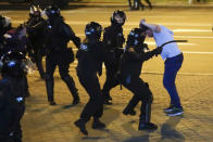 Police clash with a protester during following presidential elections in Minsk, Belarus, Monday, Aug. 10, 2020. Thousands of people have protested in Belarus for a second straight night after official results from weekend elections gave an overwhelming victory to authoritarian President Alexander Lukashenko, extending his 26-year rule. A heavy police contingent blocked central squares and avenues, moving quickly to disperse protesters and detained dozens. (AP Photo/Sergei Grits)