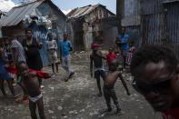 Neighbors gather outside their homes built with recycled metal sheets in the Bellecour-Cite Soleil shanty town of Port-au-Prince, Haiti, Friday, Oct. 1, 2021. Bellecour-Cité Soleil, a neighborhood of tin shacks without water, electricity or any basic services, is the stronghold of Jimmy Cherizier, aka Barbecue, a former policeman who leads the G9 gang coalition. (AP Photo/Rodrigo Abd)