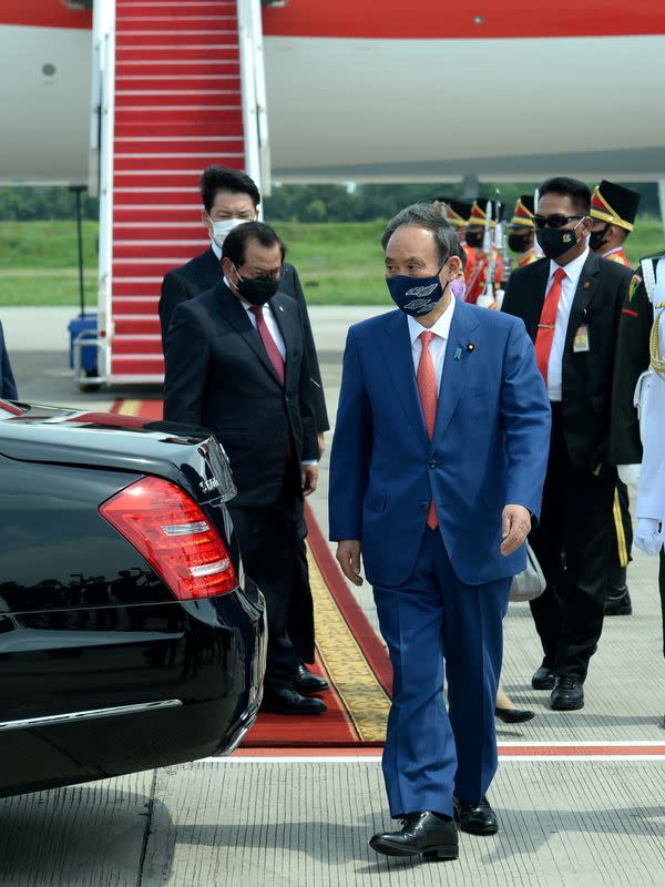 Japan's Prime Minister Yoshihide Suga walks as he arrives at Soekarno-Hatta International Airport during his visit, in Tangerang near Jakarta