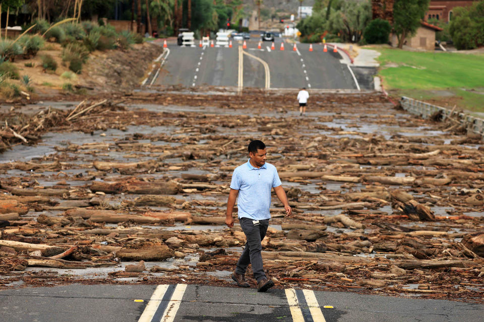 TOPSHOT - A worker from the Coachella Valley Water Department surveys the debris flow following heavy rains from Tropical Storm Hilary, at Thurderbird Country Club in Rancho Mirage, California, on August 21, 2023. Tropical Storm Hilary drenched Southern California with record rainfall, shutting down schools, roads and businesses before edging in on Nevada on August 21, 2023. California Governor Gavin Newsom had declared a state of emergency over much of the typically dry area, where flash flood warnings remained in effect until this morning. (David Swanson / AFP - Getty Images)