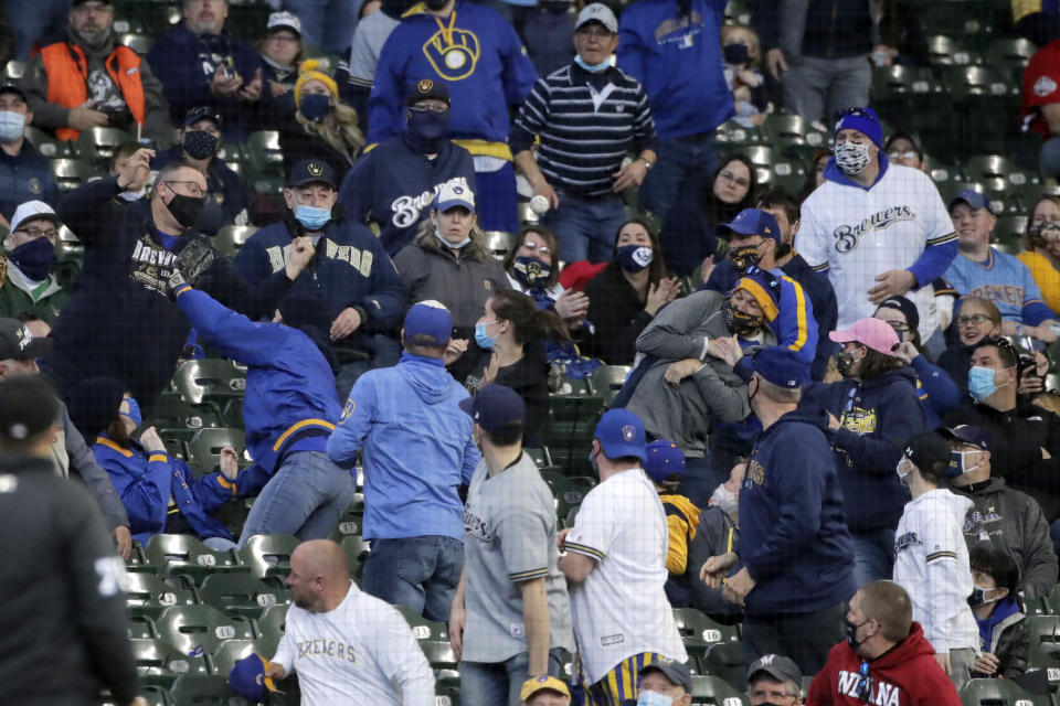 Fans watch a ball bounce into the stands during the third inning of an opening day baseball game between the Milwaukee Brewers and the Minnesota Twins on Thursday, April 1, 2021, in Milwaukee. (AP Photo/Aaron Gash)