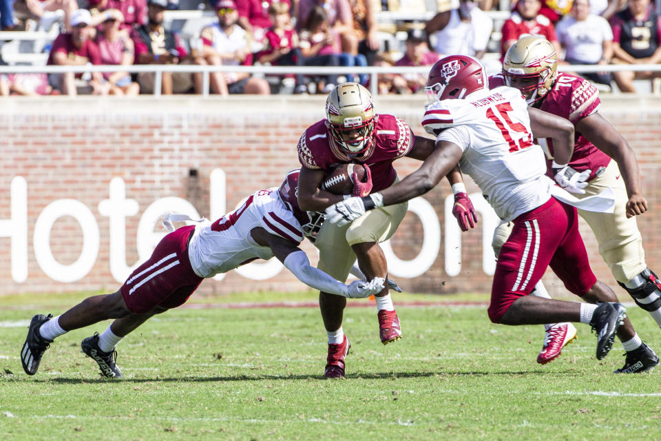 Massachusetts defensive back Cody Jones (29) and defensive lineman Viczaril Alobwede (15) converge on Florida State running back D.J. Williams (1) in the second half of an NCAA college football game in Tallahassee, Fla., Saturday, Oct. 23, 2021. Florida State defeated UMass 59-3. (AP Photo/Mark Wallheiser)