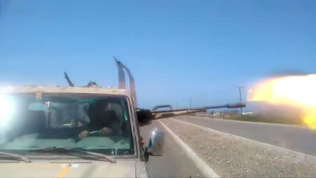 Members of UAE-backed fighters, Yemeni Resistance Giants' Brigade fire the gun from the back of truck, near airport on the outskirts of Hodeidah, Yemen, June 19, 2018 in this still image taken from video. YEMENI RESISTANCE GIANTS' BRIGADE/REUTERS