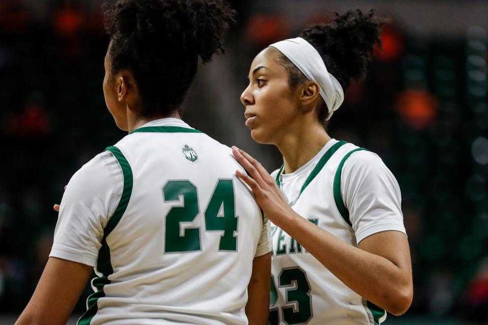 West Bloomfield guard Summer Davis (23), center, comforts guard Indya Davis (24) regarding a call during the second half of the MHSAA Division 1 girls basketball final against Rockford at Breslin Center in East Lansing on Saturday, March 18, 2023.
